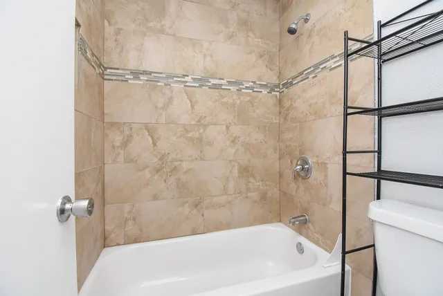 a bathroom with a white bath tub a shower and a sink