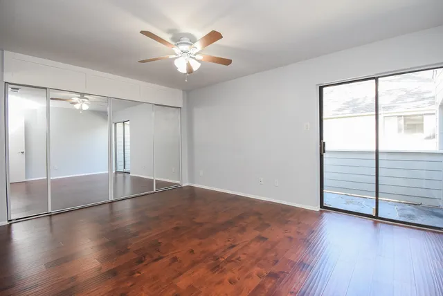 an empty room with wooden floor and window