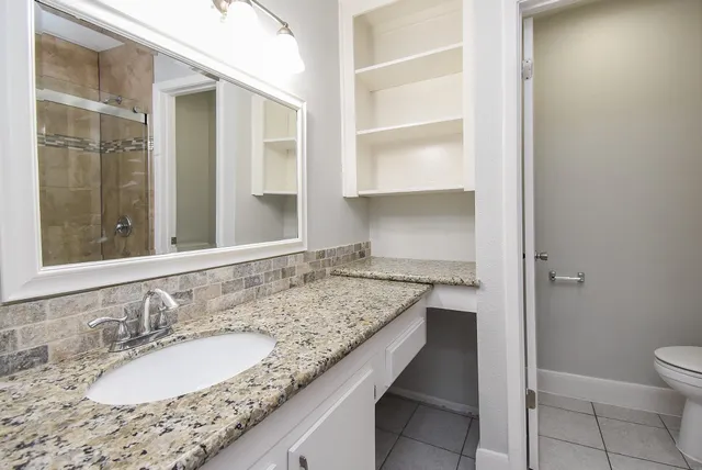 a bathroom with a granite countertop sink and a mirror