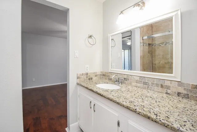 a bathroom with a granite countertop sink and a mirror