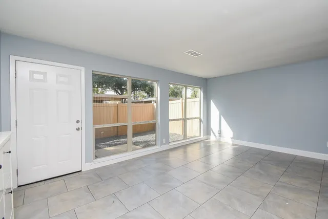 an empty room with floor to ceiling windows and carpet