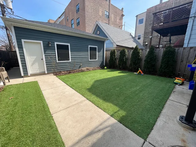 a backyard of a house with barbeque oven table and chairs