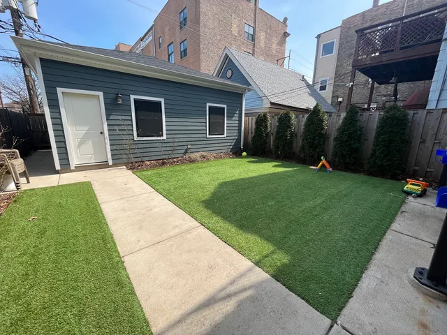 a backyard of a house with barbeque oven table and chairs