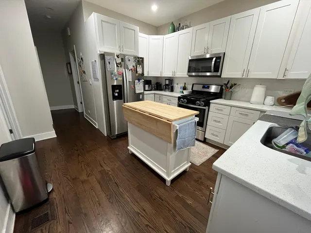 a kitchen with stainless steel appliances a refrigerator a stove a microwave and wooden floors