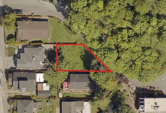 a view of a backyard with wooden fence and a bench