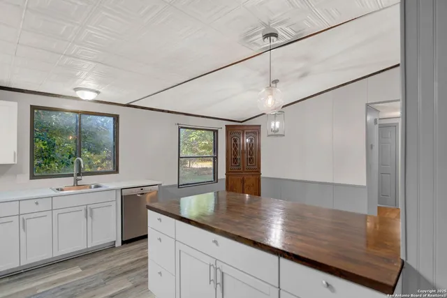 a kitchen with kitchen island a counter top space wooden floor and stainless steel appliances