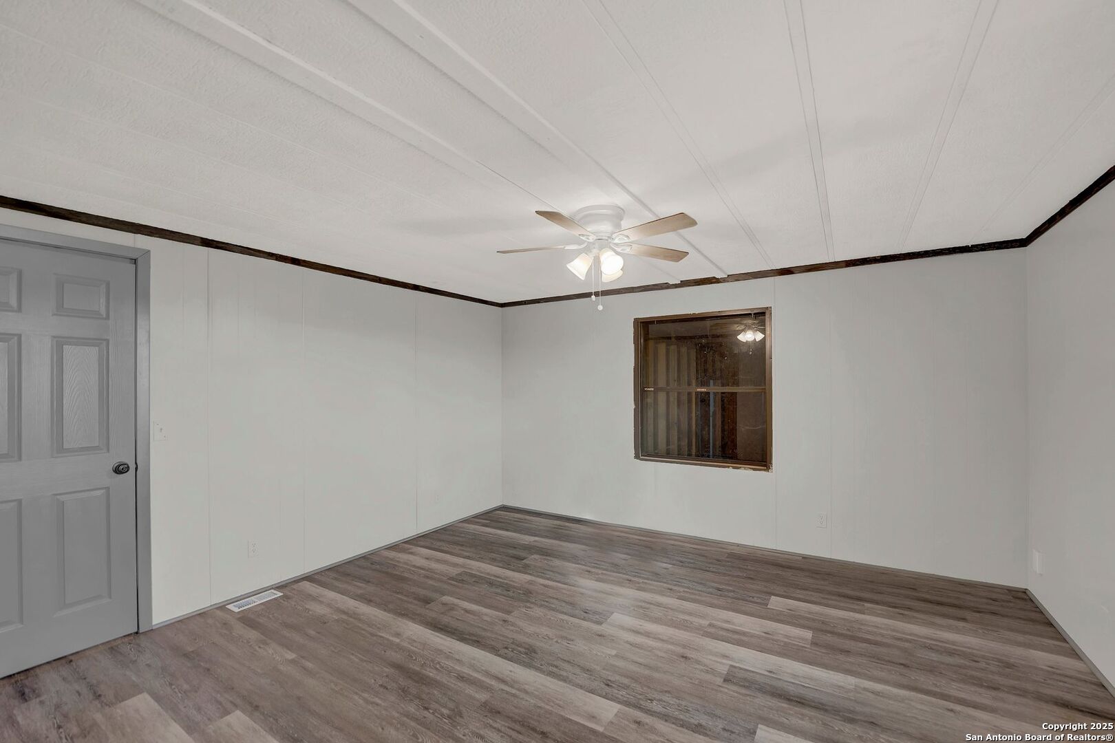 245 Bandera Drive Bandera, TX 78003 - Photo 23 of 37 a view of an empty room with wooden floor and a window