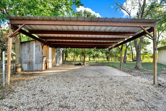 a view of a backyard of a house with a floor to ceiling window and tree