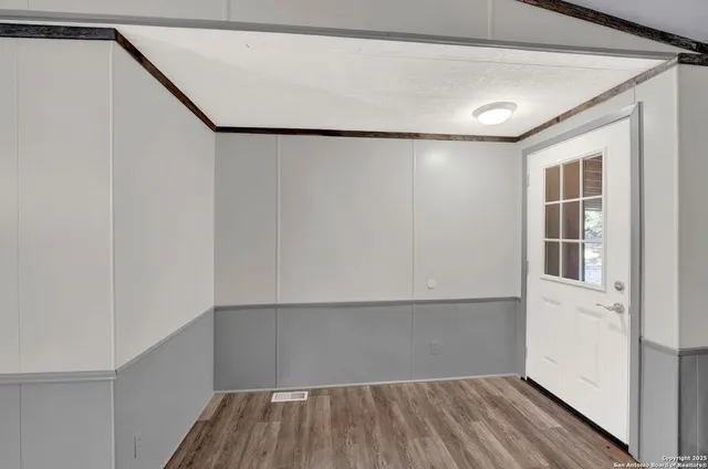 a view of empty room with wooden floor and fireplace