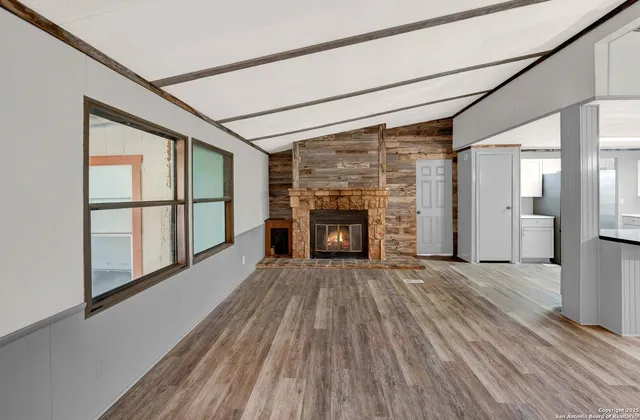 a view of an empty room with a fireplace and a window