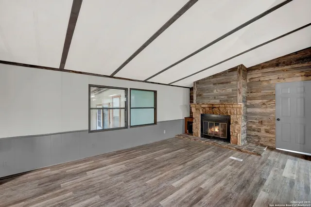 a view of an empty room with a fireplace and a window