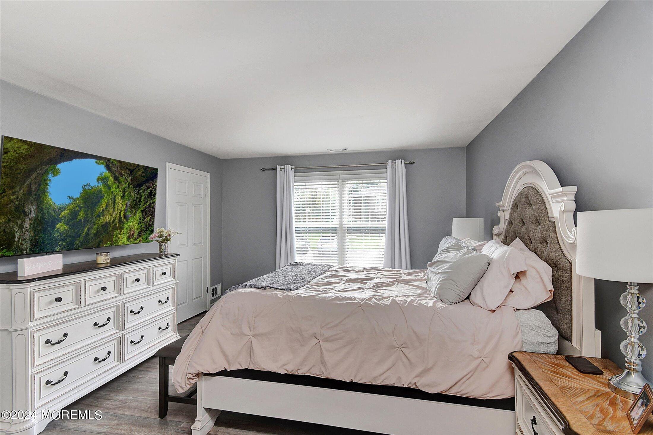 503 Harding Road, Unit 1 Freehold, NJ 07728 - Photo 14 of 20 a large bed sitting in a bedroom next to a window with dresser