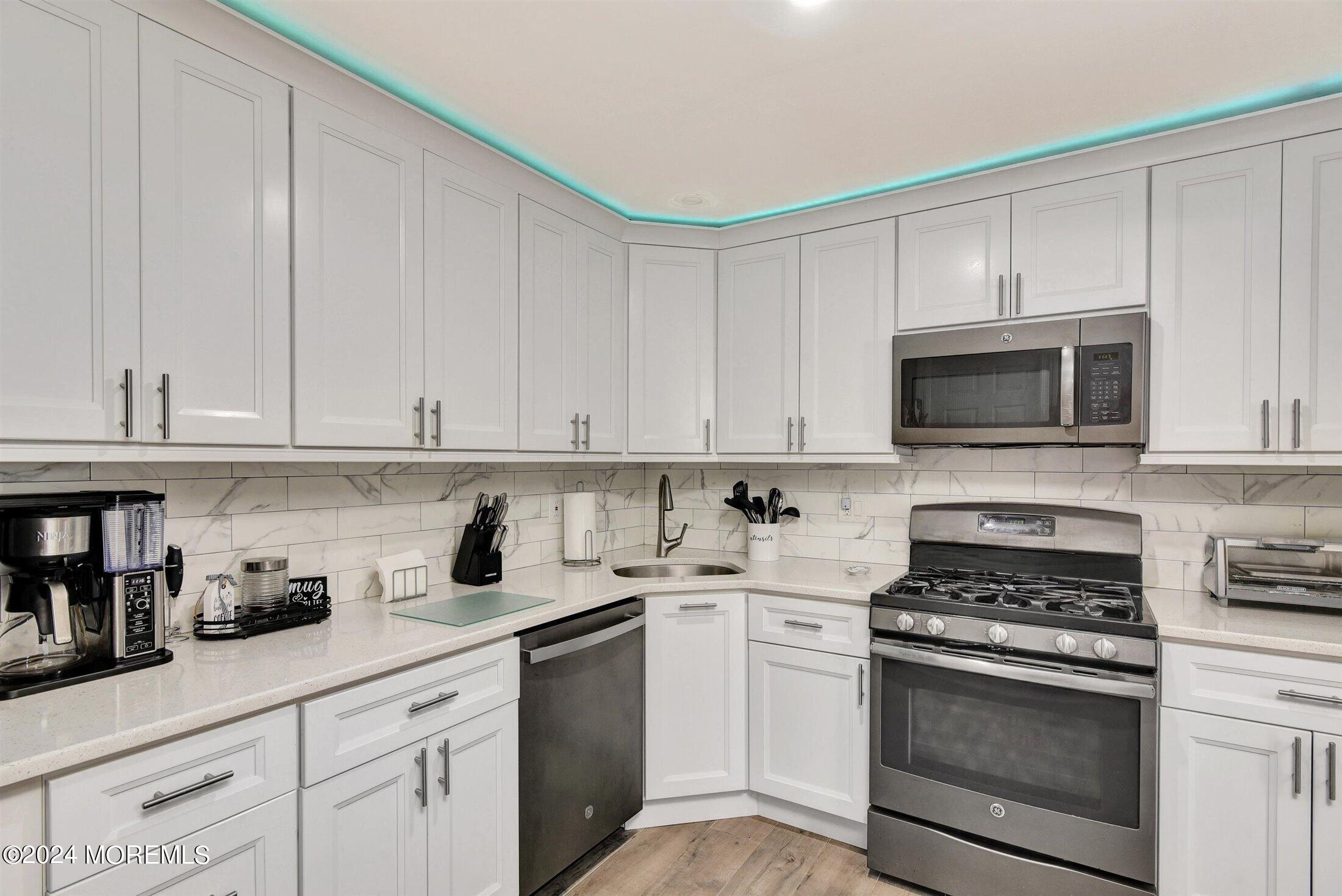 503 Harding Road, Unit 1 Freehold, NJ 07728 - Photo 8 of 20 a kitchen with white cabinets and stainless steel appliances