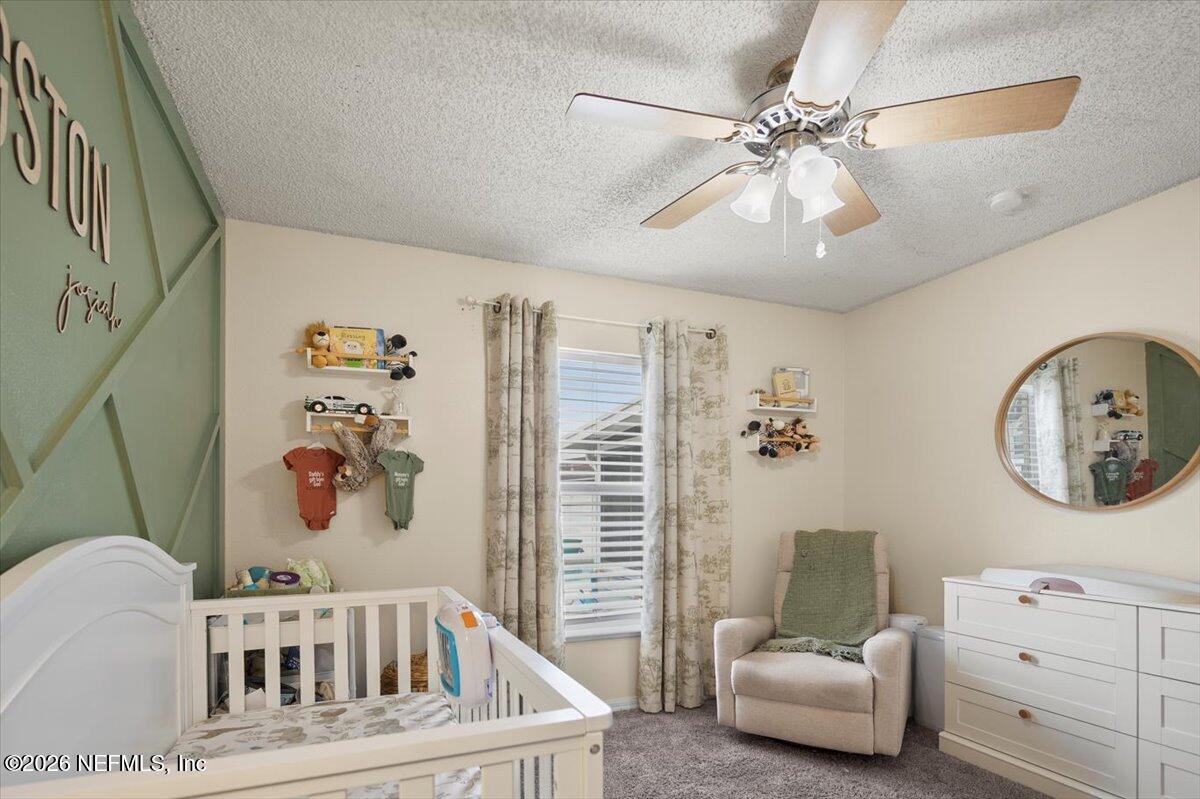 10310 Woodley Point Road Jacksonville, FL 32218 - Photo 12 of 30 a living room with furniture and a chandelier