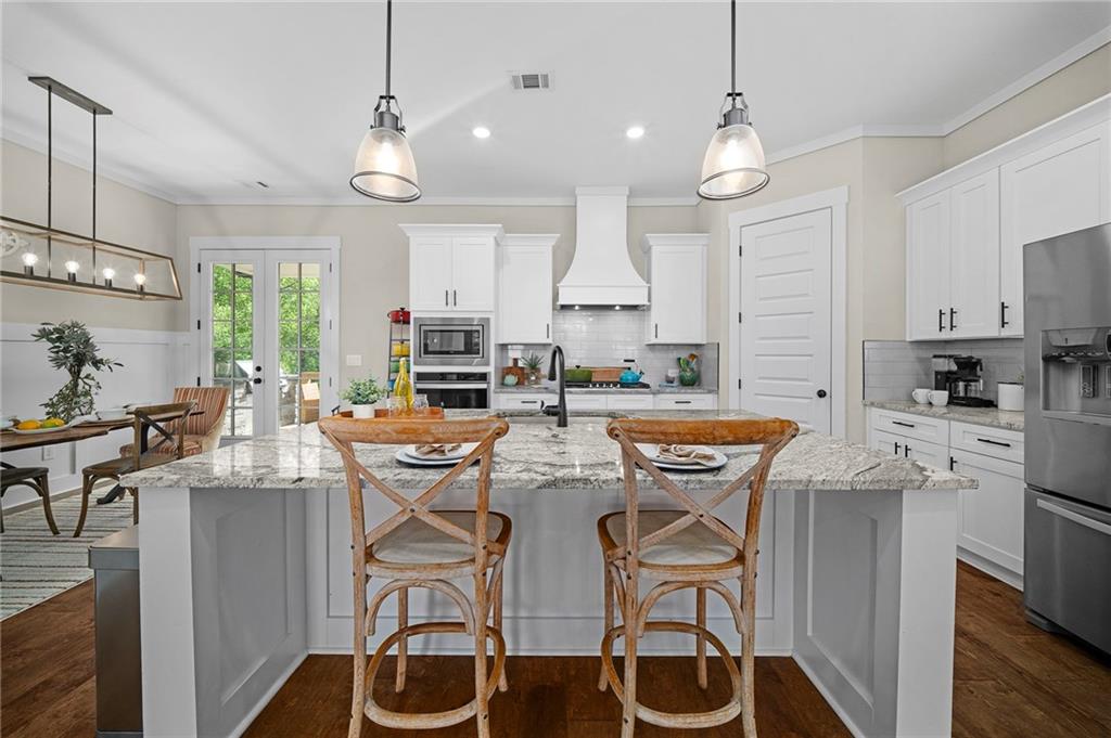 392 London Road Ball Ground, GA 30107 - Photo 10 of 53 a kitchen with stainless steel appliances kitchen island granite countertop a table and chairs in it
