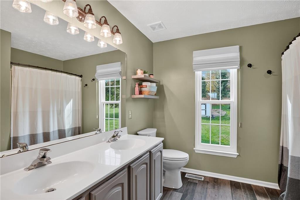 224 Field Club Circle McKees Rocks, PA 15136 - Photo 20 of 41 a bathroom with a sink a toilet a mirror a vanity and window