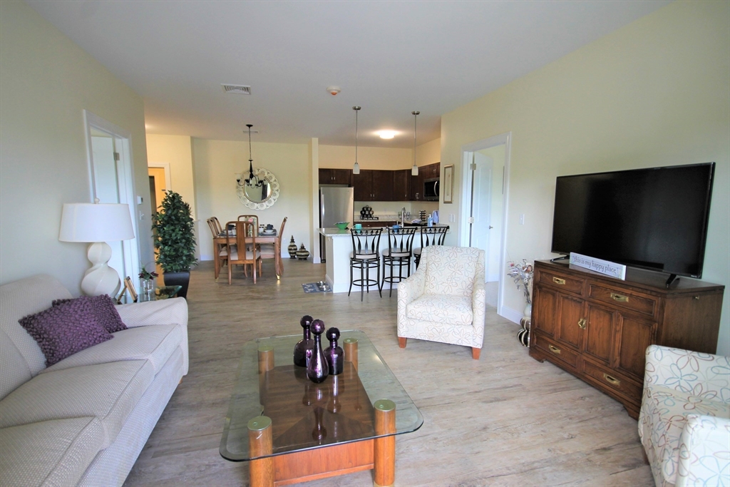 2 Regency Village Way, Unit 208 Merrimac, MA 01860 - Photo 14 of 19 a living room with furniture and a flat screen tv