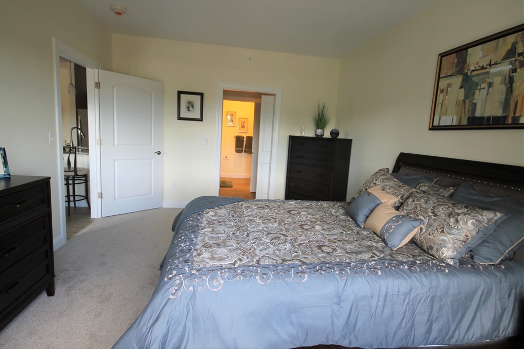 2 Regency Village Way, Unit 208 Merrimac, MA 01860 - Photo 17 of 19 a bedroom with a bed and a dresser