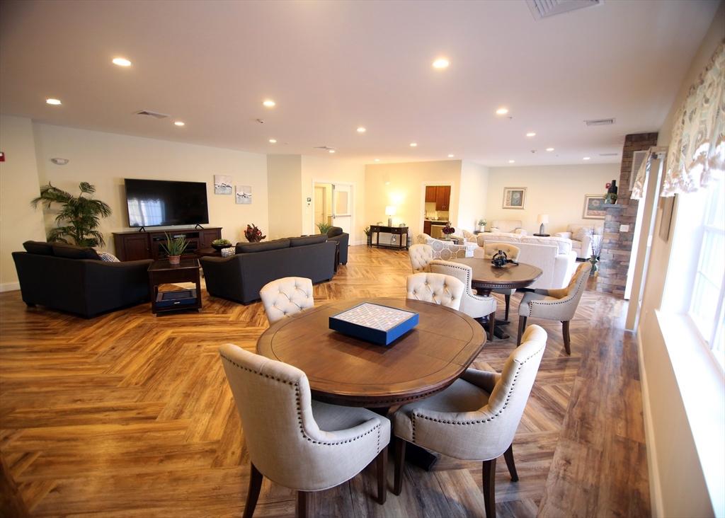 2 Regency Village Way, Unit 208 Merrimac, MA 01860 - Photo 3 of 19 a living room with furniture and a flat screen tv