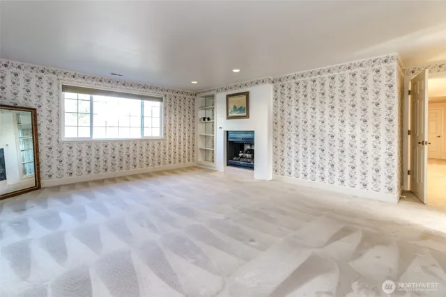 a view of an empty room with a fireplace and a window