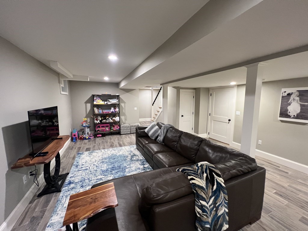 11 Fletcher Road, Unit 11 Bedford, MA 01730 - Photo 23 of 31 a living room with furniture and a flat screen tv