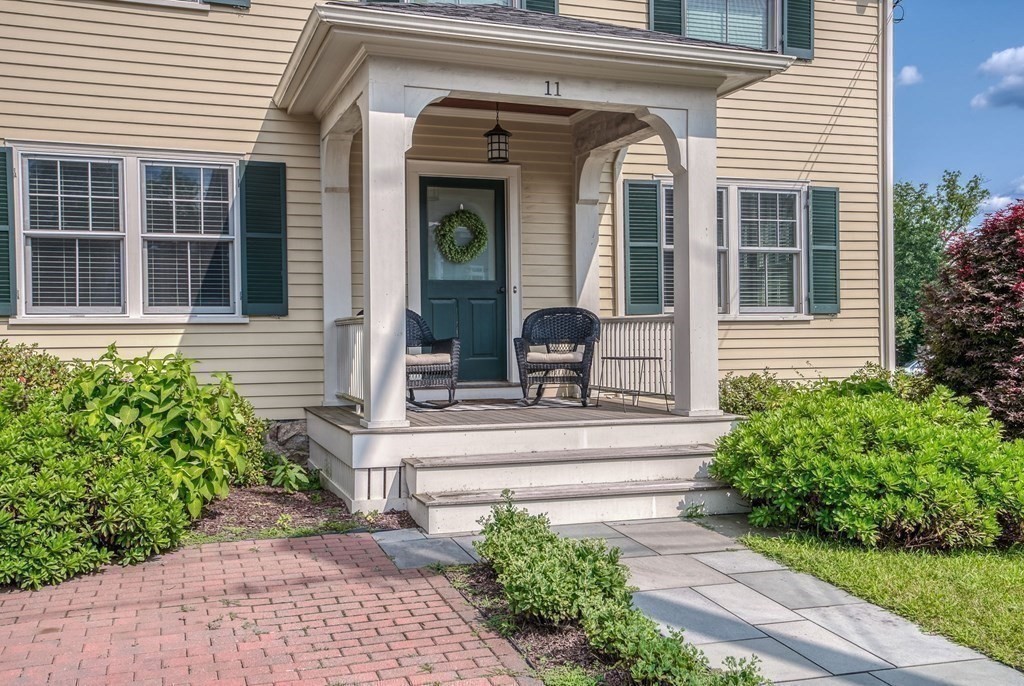11 Fletcher Road, Unit 11 Bedford, MA 01730 - Photo 26 of 31 a view of brick house with potted plants and a bench