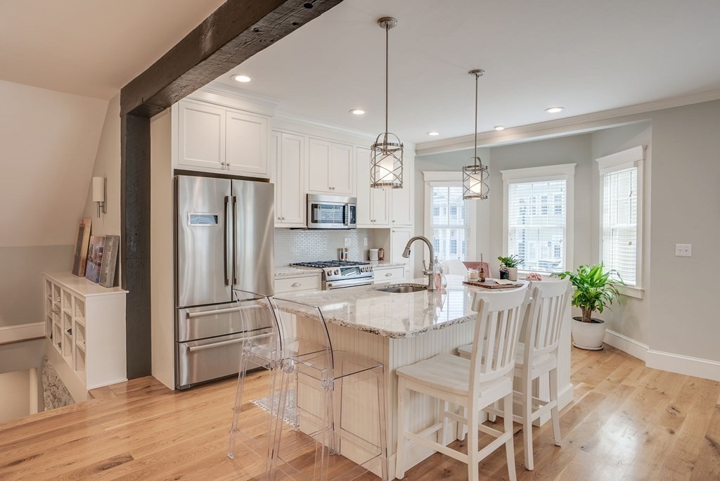 11 Fletcher Road, Unit 11 Bedford, MA 01730 - Photo 3 of 31 a kitchen with granite countertop a refrigerator and a wooden floor