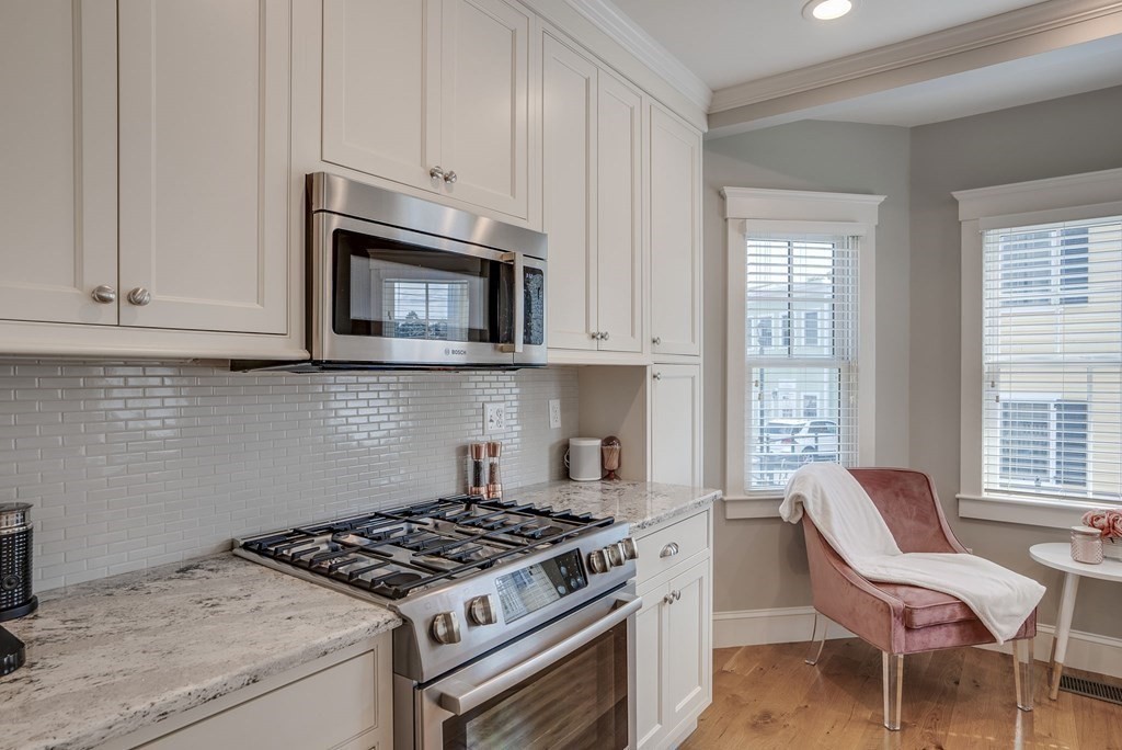 11 Fletcher Road, Unit 11 Bedford, MA 01730 - Photo 8 of 31 a kitchen with granite countertop a stove top oven microwave and cabinets