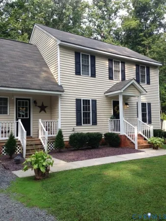a front view of a house with a garden and yard