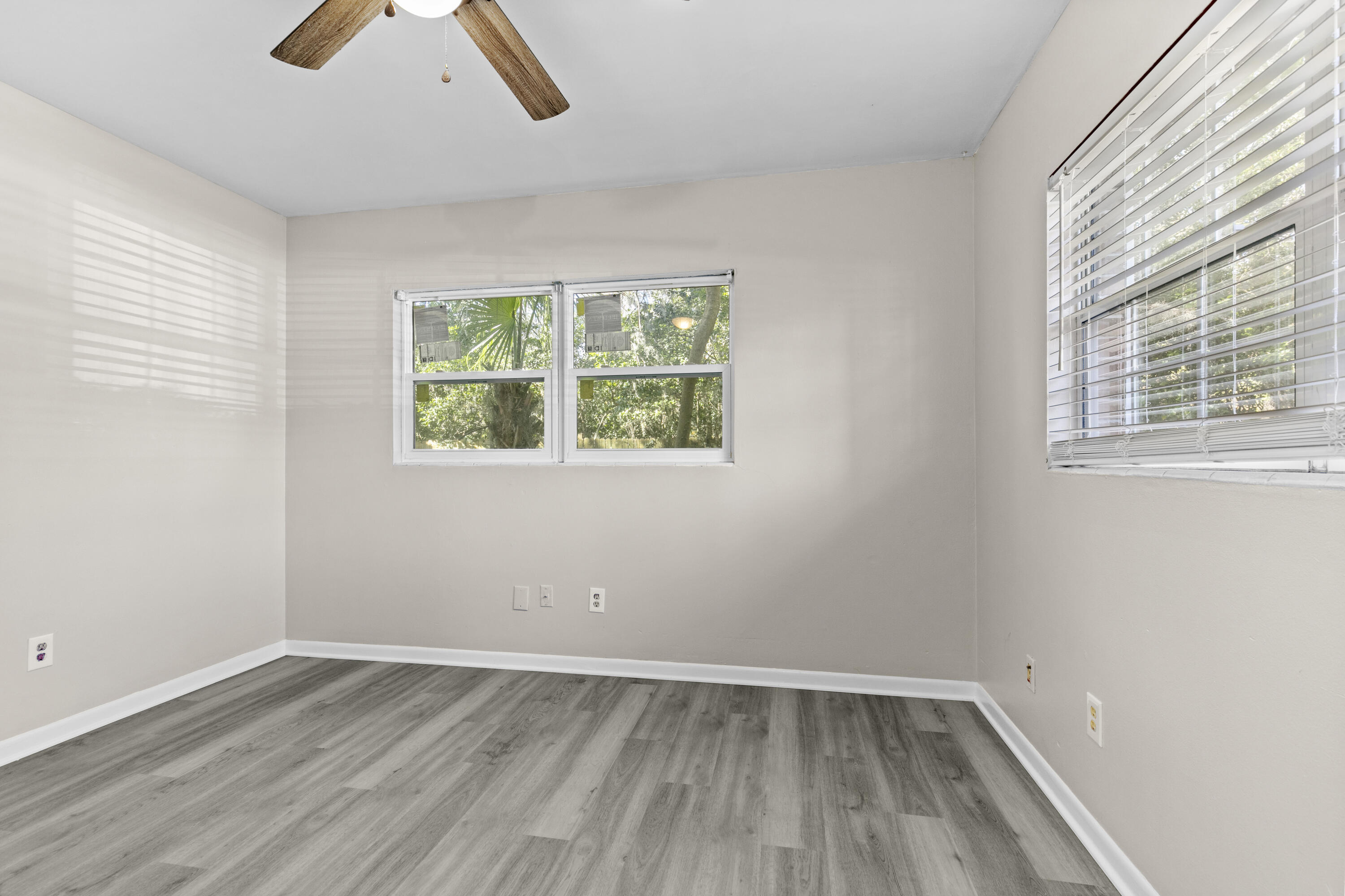 3331 Northwest 27th Avenue Gainesville, FL 32605 - Photo 29 of 29 an empty room with wooden floor and windows