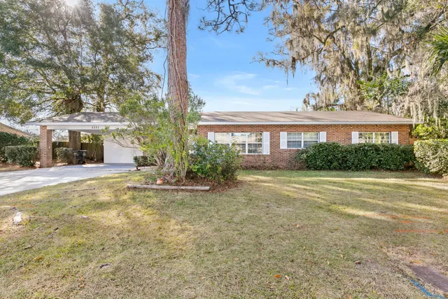 a view of a house with a large tree and plants