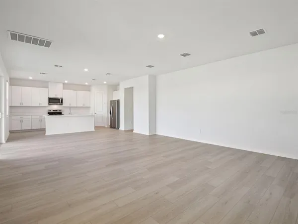 a view of an empty room with a kitchen