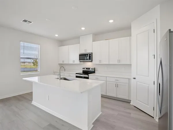 a kitchen with cabinets a sink and appliances