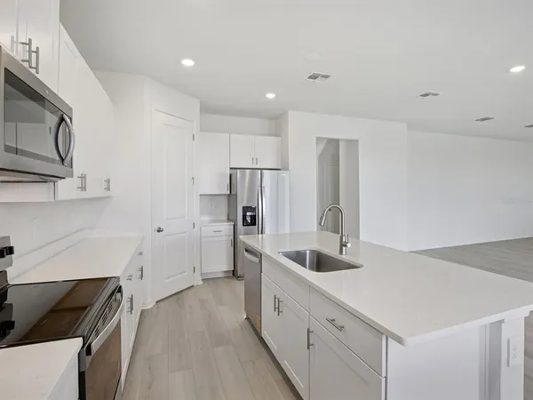 a kitchen with stainless steel appliances a refrigerator sink and microwave