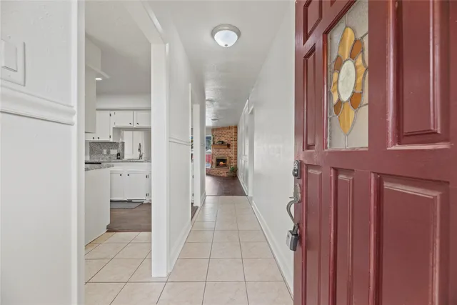 an empty room with wooden floor fireplace and fan