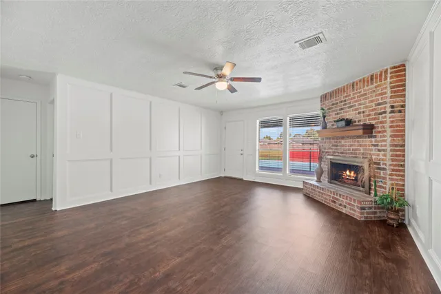 a view of empty room with wooden floor and fireplace