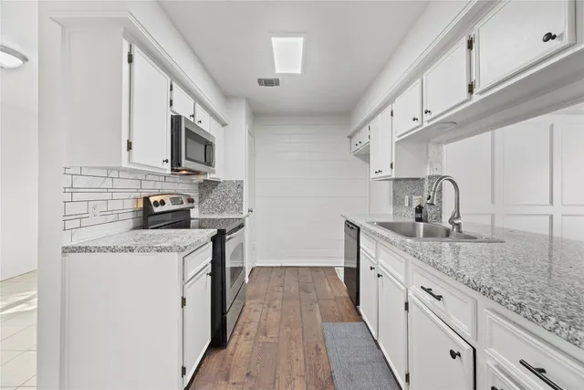 a kitchen with stainless steel appliances granite countertop a sink stove and cabinets