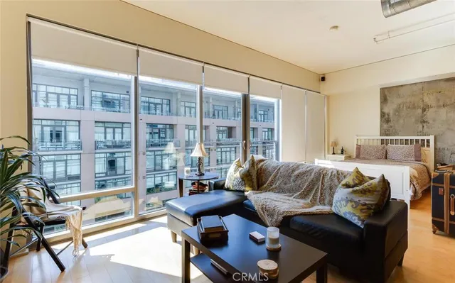 a living room with furniture a flat screen tv and a floor to ceiling window