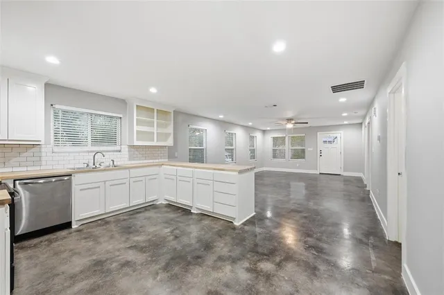 a large white kitchen with a white countertops and cabinets