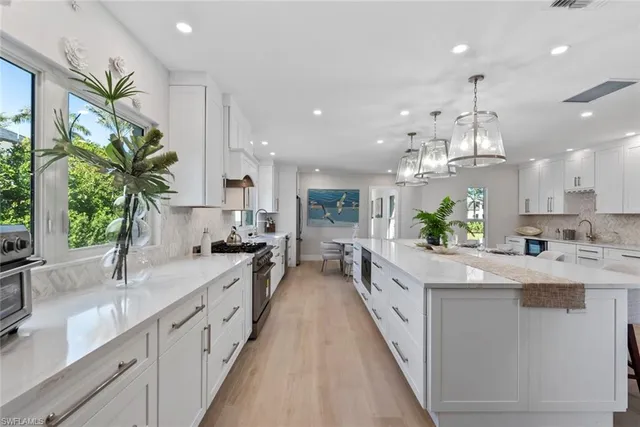 a large kitchen with granite countertop lots of counter space and a sink