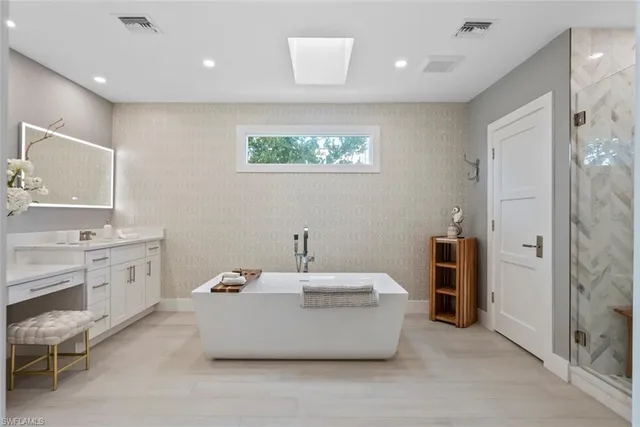 a bathroom with a tub sink and mirror