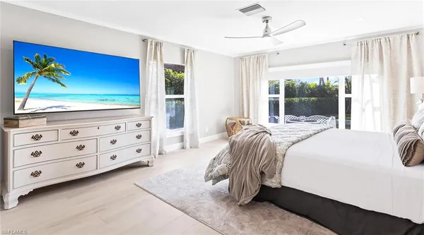 a view of a patio with table and chairs potted plants and a palm tree