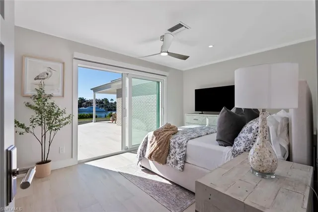a bedroom with a large bed and a potted plant