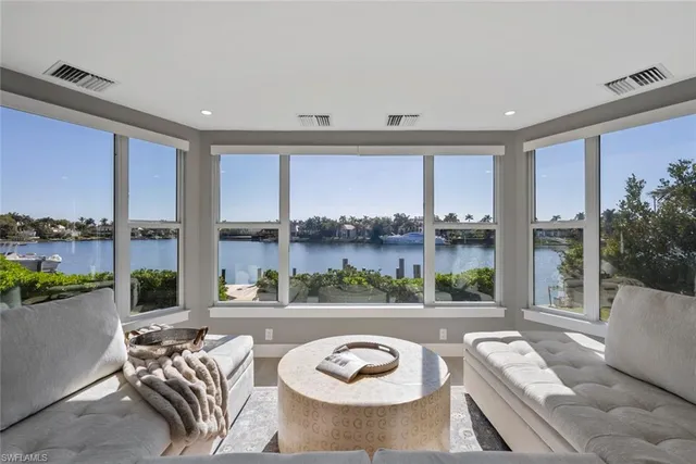 a living room with large windows and a table