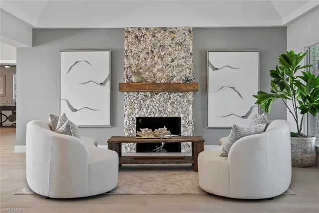 a living room with furniture a fireplace and a potted plant