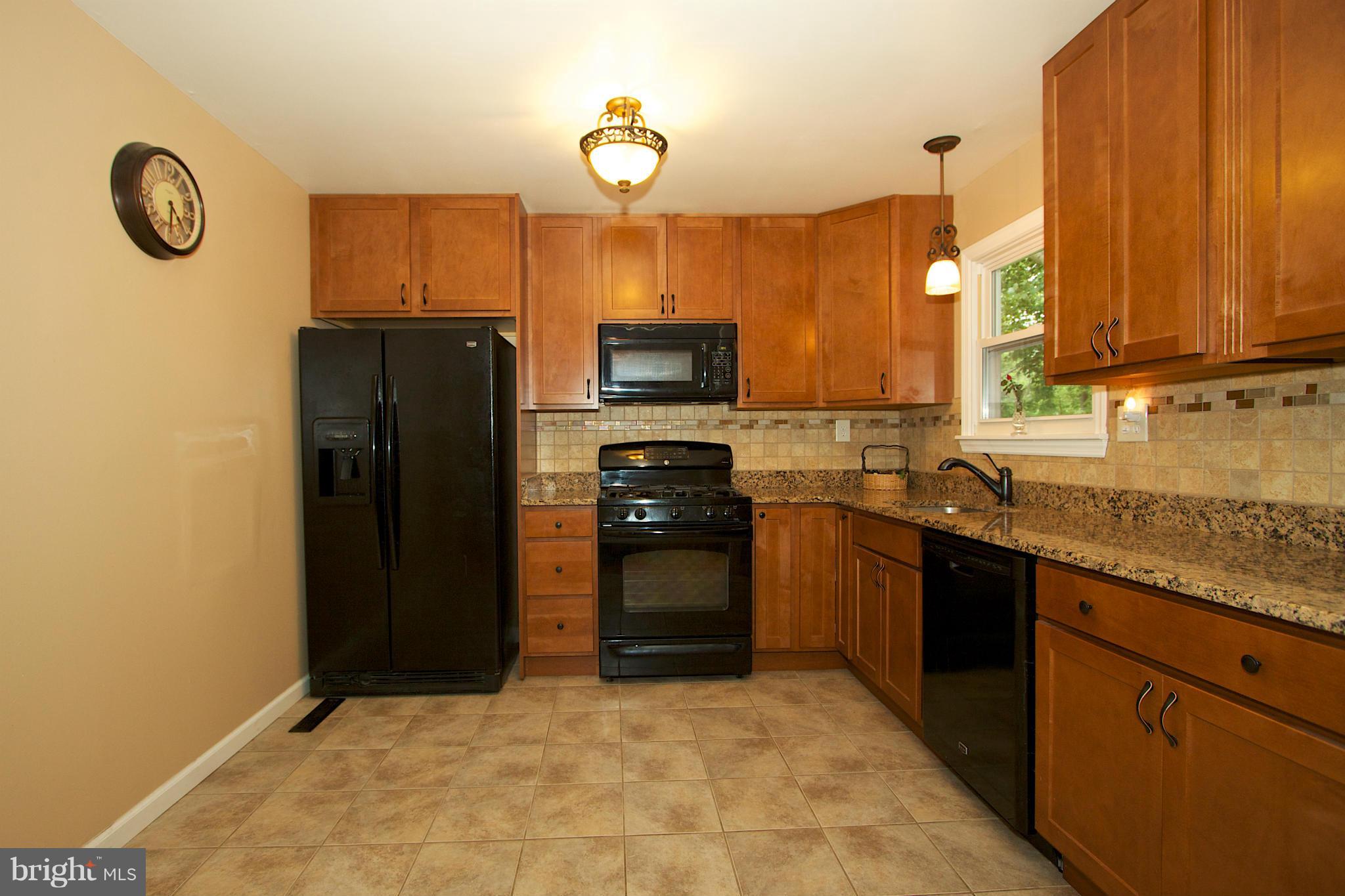 332 Laburnum Road Edgewood, MD 21040 - Photo 8 of 22 a kitchen with granite countertop a refrigerator a stove top oven and a sink