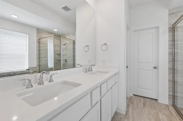 a bathroom with double sink and a large mirror