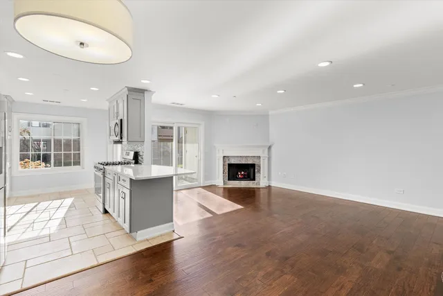 an open kitchen with white cabinets and fireplace