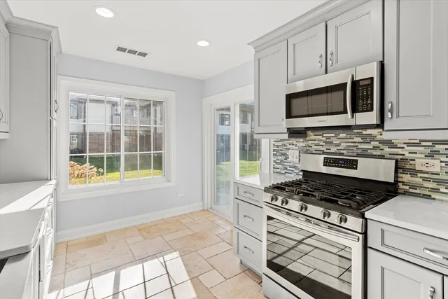 a kitchen with stainless steel appliances granite countertop a stove and a microwave
