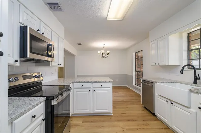 a kitchen with a sink stove top oven and refrigerator